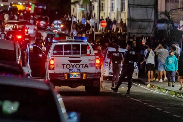 Полицейские машины патрулируют толпу после закрытия ночных клубов в Суве, Фиджи