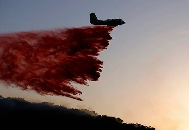 Самолет пожарной службы Cal Fire сбрасывает огнезащитное средство перед пожаром Сэнди 18 мая 2026
