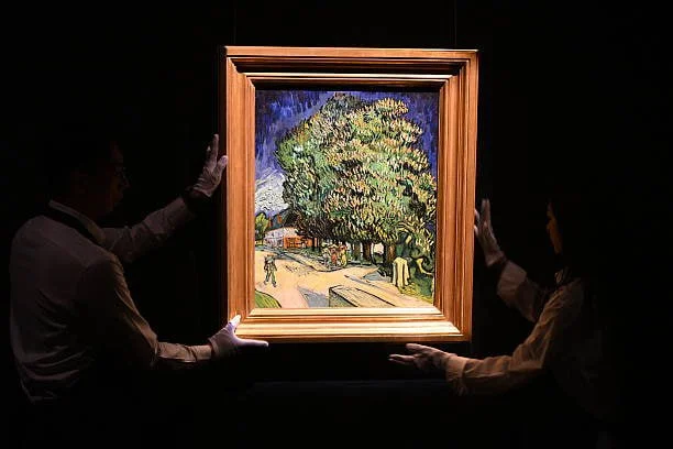Сотрудники Sothebys рассматривают картину Винсента ван Гога Каштаны в цвету на предварительном